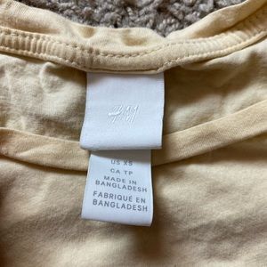 H&M cropped yellow t-shirt with a note on the bottom.